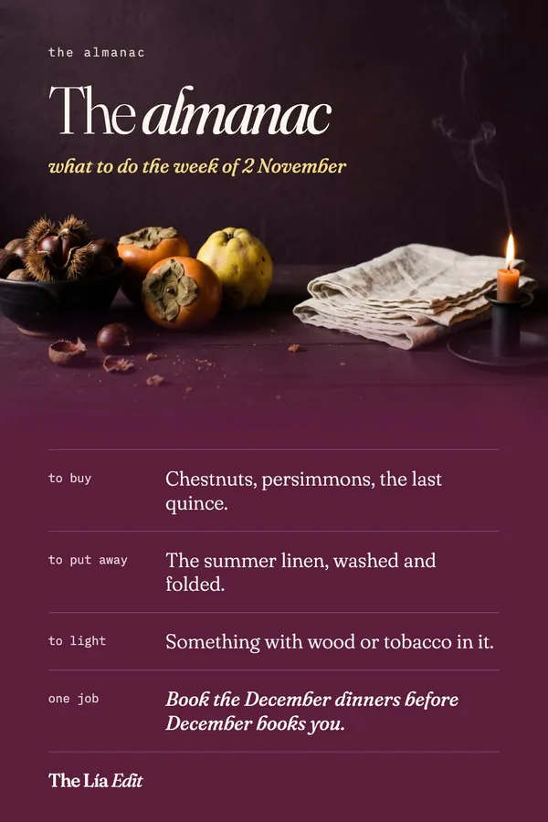 Seasonal living still life with chestnuts, persimmons, quince, linen napkins and a lit candle